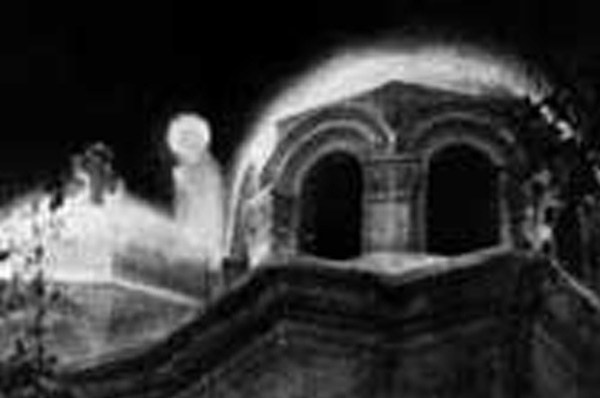 A luminous figure beside the arched windows of a dome at night