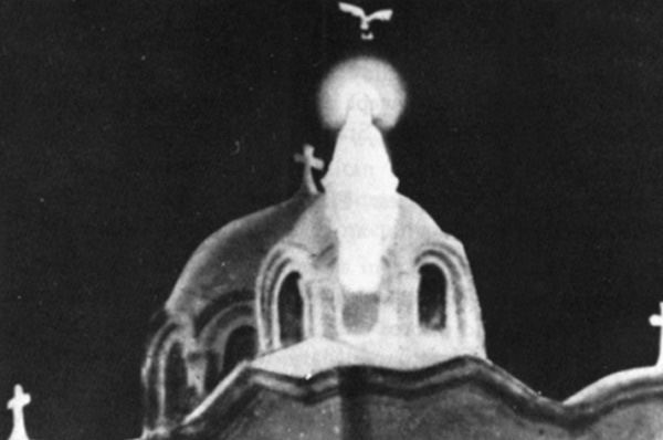 The Virgin Mary in light above the central dome, a dove above her